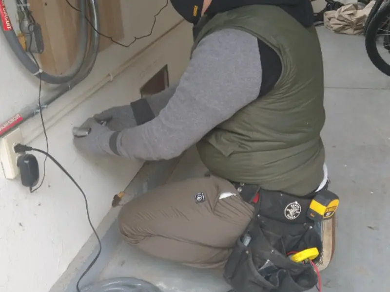 Electrician performing outlet wiring in a Stanley garage